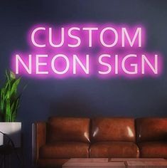 a neon sign that reads custom neon sign in front of a couch and coffee table