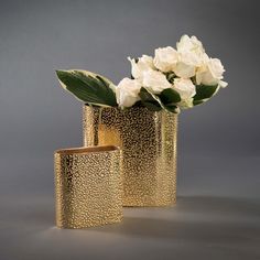 two gold vases with white flowers in them