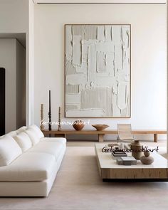 a living room filled with furniture and a painting on the wall above it's coffee table