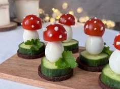 cucumber and mushroom appetizers are displayed on a cutting board