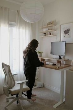 a woman standing in front of a computer desk