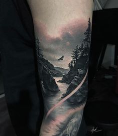 a man's arm with a landscape tattoo on it