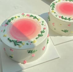 two cakes sitting on top of a white table