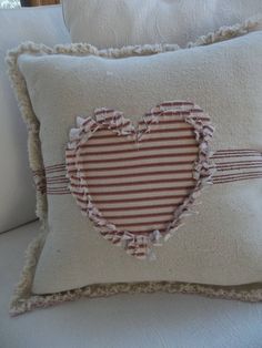 a heart shaped pillow on top of a white couch