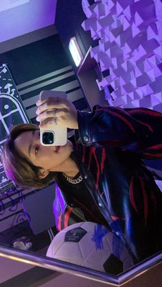 a woman taking a selfie in front of a mirror with a soccer ball on it