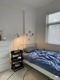 a bedroom with a bed, dresser and lamp