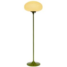 a green floor lamp with a white light on the top and bottom part of it