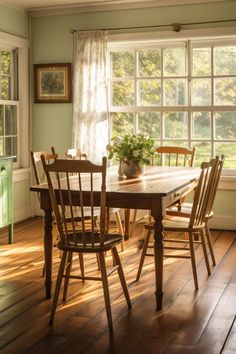 a dining room table with four chairs and a potted plant on top of it