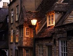 an old stone building with two windows and a street light on the side of it