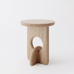 a wooden stool with a circular hole in the middle and a curved section at the bottom