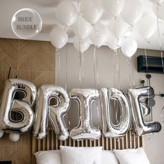 balloons that spell out bridal are hanging from the ceiling in front of a bed