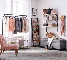 a room with clothes and shoes on racks, a chair and a window in the background