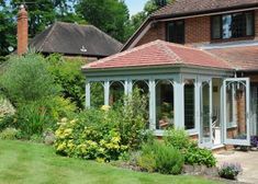 a house with a garden in front of it and lots of flowers around the yard