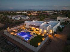 an aerial view of a house with a swimming pool at night in the middle of nowhere