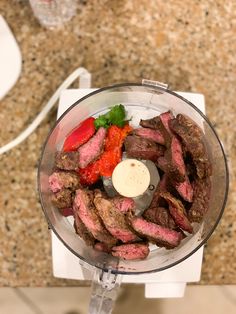 a food processor filled with meat and vegetables