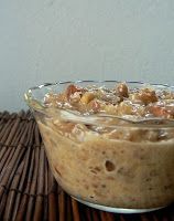 a glass bowl filled with food sitting on top of a bamboo mat next to a white wall