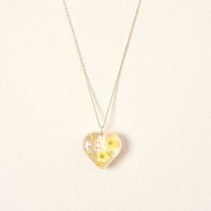 a heart shaped necklace with yellow flowers on it