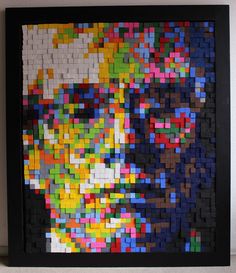 an art piece made out of legos is shown in a black frame on the wall