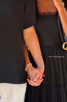 two people holding hands while standing next to each other