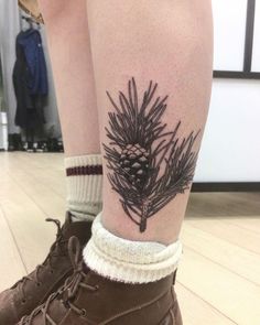 a person with a pine cone tattoo on their leg