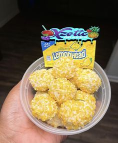 a hand holding a plastic container filled with lemonade cookies