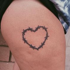 a heart shaped barbed wire tattoo on the thigh