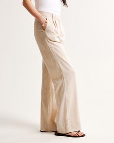 Our signature A&F Sloane Tailored Pant with a low rise, in our breezy linen-blend fabric, that's perfect for dressing up or down. Featuring figure-flattering pleating details, a functional fly and pockets and a partially elasticated waistband for ultimate adjustability. The intended length hits the bottom of a flat shoe. Please reference our size chart to determine your perfect size and inseam! Fitted Linen Wide Leg Pants For Work, Effortless Beige Bottoms, Chic Relaxed Fit Flax Bottoms, Cotton Bottoms In Flax Color For Workwear, Chic Neutral Wide Leg Linen Pants, Effortless Linen Pants For Summer, Spring Neutral Linen Wide Leg Pants, Neutral Linen Loungewear Bottoms, Chic Flax Relaxed Fit Pants