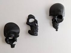 three black skulls are hanging on the wall