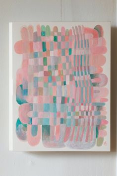 an abstract painting hangs on the wall in front of a white frame with pink, blue and green squares