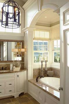 a bath room with a tub and a chandelier hanging from it's ceiling