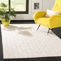 a yellow chair sitting on top of a black floor next to a white area rug