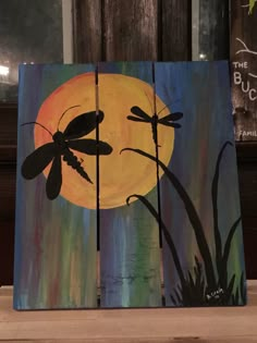 a painting of two dragonflies in front of a full moon