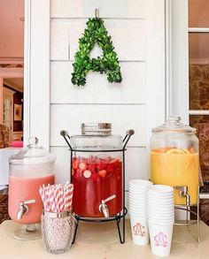 a table topped with drinks and cups filled with liquid