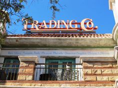 a building with a sign that reads trading co on it's roof above the entrance