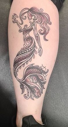 a woman's leg with a tattoo design on it