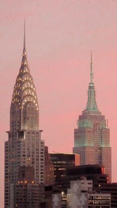 an airplane is flying in the sky over some tall buildings at sunset or sunrise time