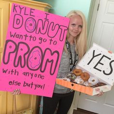 a woman holding a sign that says donuts want to go to prom with anyone else but you