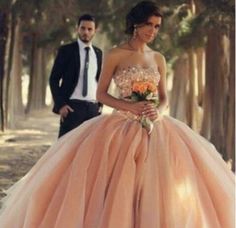 a man standing next to a woman wearing a dress with flowers on the bottom and in front