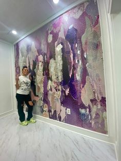 a woman standing in front of a large painting