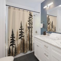 a bathroom with a shower curtain that has trees on it