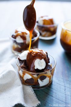 caramel sauce being drizzled over ice cream in small bowls on a table