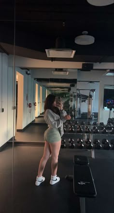 a woman is taking a selfie in the gym