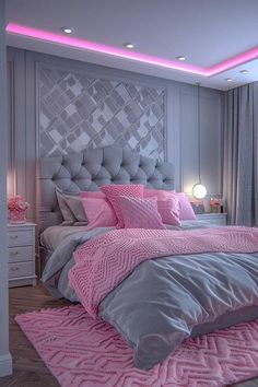 a pink and grey bedroom with a large bed