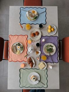 an overhead view of a dining table with food on it and placemats in the middle