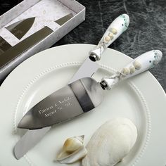 a white plate topped with a knife next to a clamshell and a box