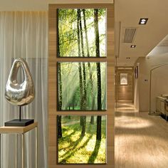 the interior of a modern home with wood flooring and white curtains on the windows