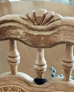 an old wooden bench with blue beads on the seat and wood slats around it