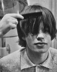 a young man is getting his hair cut