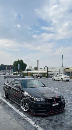 a black car is parked in the parking lot