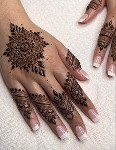 a woman's hand with henna tattoos on it